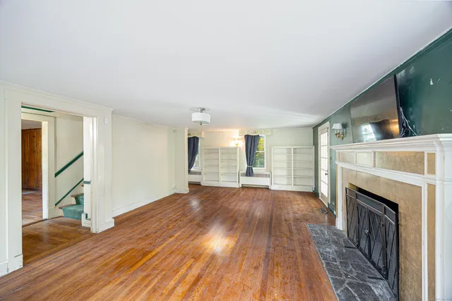 a view of empty room with wooden floor and fireplace
