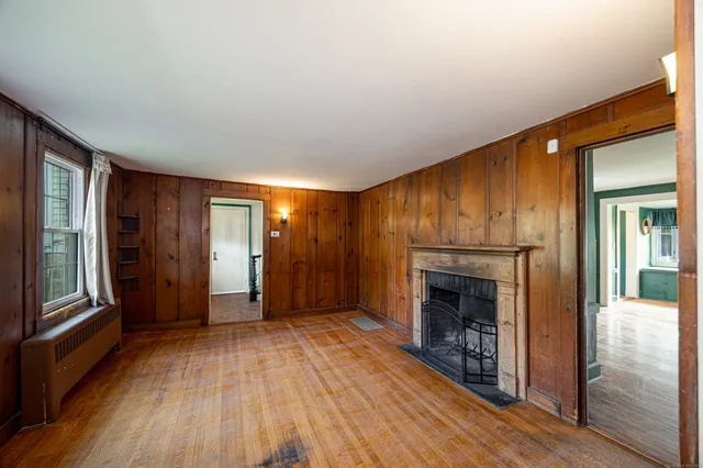 wooden floor fireplace and natural light in room