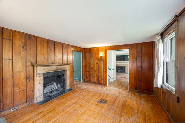 a view of an empty room with a fireplace and a window