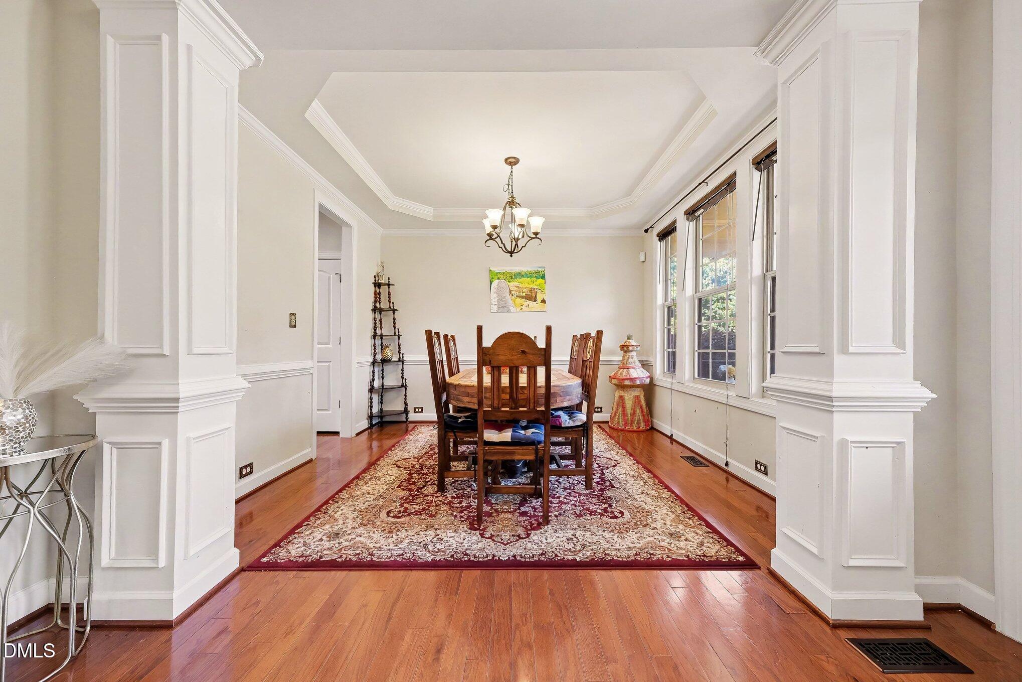 4000 Banks Stone Drive Raleigh, NC 27603 - Photo 13 of 60 a dining room with wooden floor a chandelier a wooden table and chairs