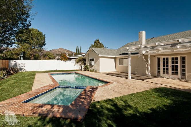 a view of a house with a yard and potted plants
