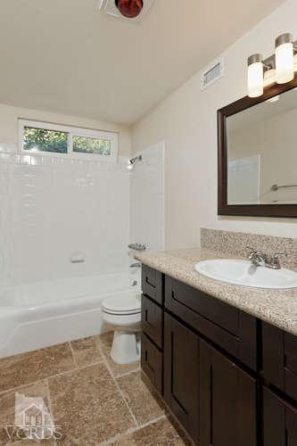 187 Kanan Road Oak Park, CA 91377 - Photo 17 of 20 a bathroom with a granite countertop sink a toilet and a mirror