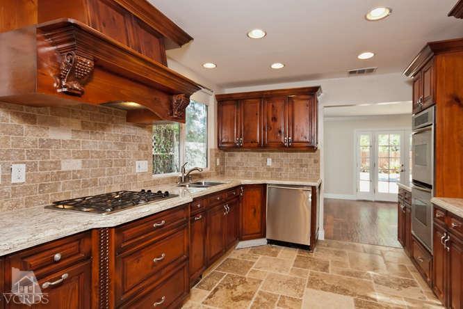 187 Kanan Road Oak Park, CA 91377 - Photo 8 of 20 a kitchen with stainless steel appliances granite countertop a stove a sink and a microwave