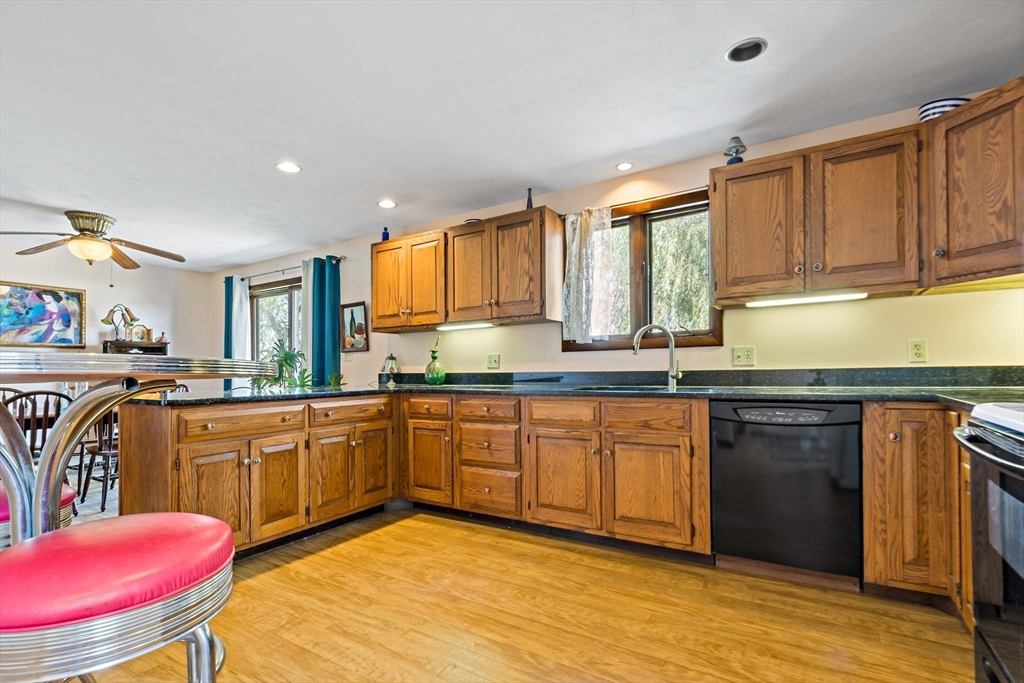 3211 Main Road Tiverton, RI 02878 - Photo 15 of 34 a kitchen with stainless steel appliances granite countertop a kitchen island hardwood floor sink stove dining table and chairs