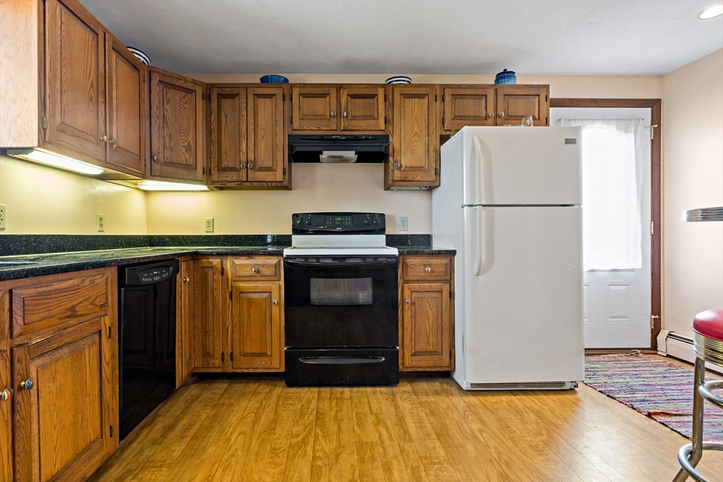 3211 Main Road Tiverton, RI 02878 - Photo 17 of 34 a kitchen with a refrigerator a stove and wooden cabinets