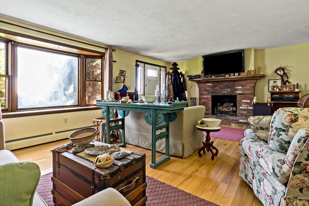 3211 Main Road Tiverton, RI 02878 - Photo 25 of 34 a living room with furniture a fireplace and a flat screen tv