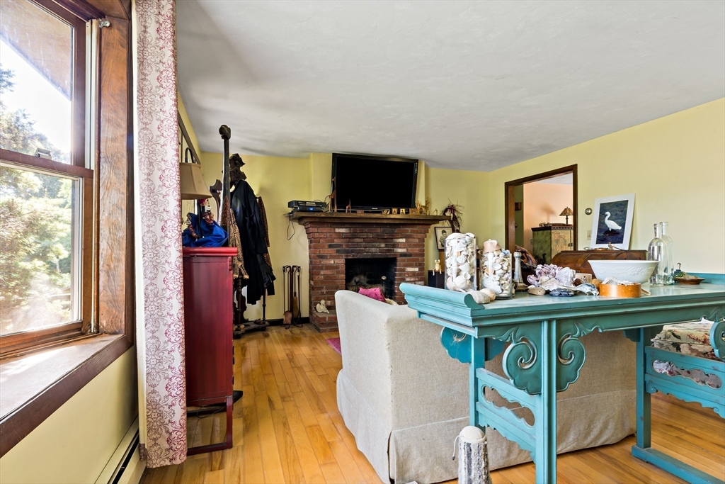 3211 Main Road Tiverton, RI 02878 - Photo 26 of 34 a living room with furniture a flat screen tv and a fireplace
