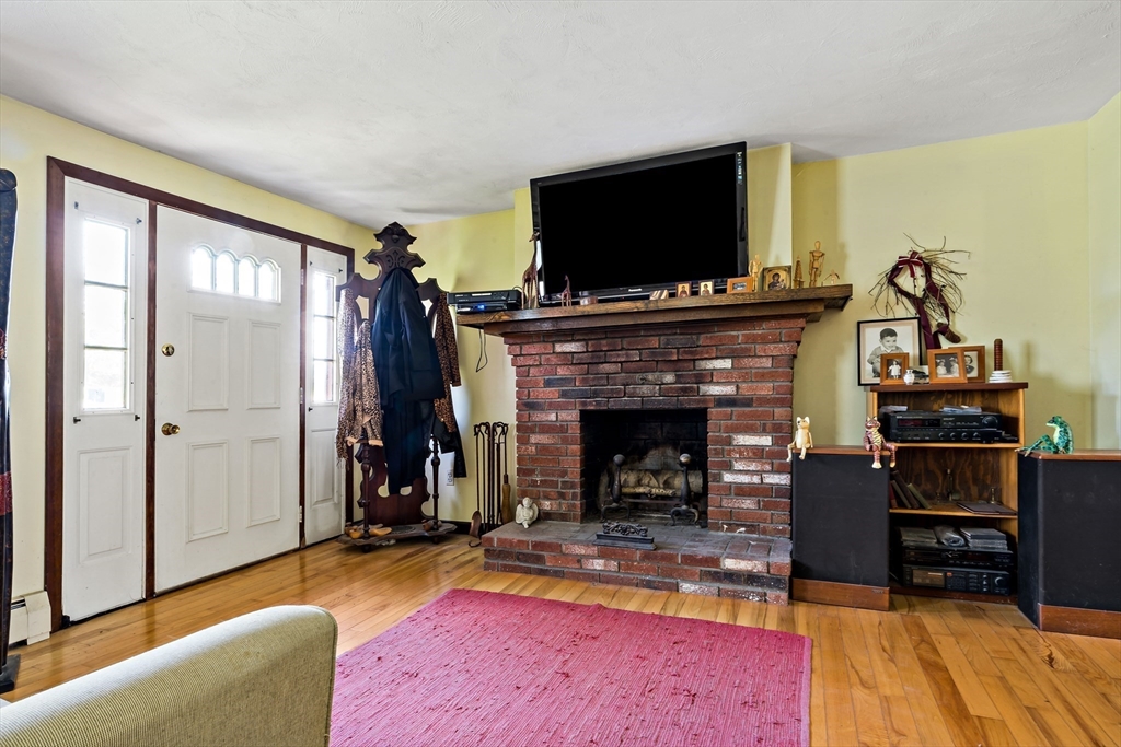 3211 Main Road Tiverton, RI 02878 - Photo 27 of 34 a living room with furniture a flat screen tv and a fireplace
