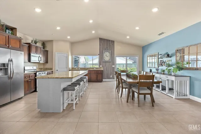 a kitchen with kitchen island granite countertop wooden cabinets a counter top space and stainless steel appliances