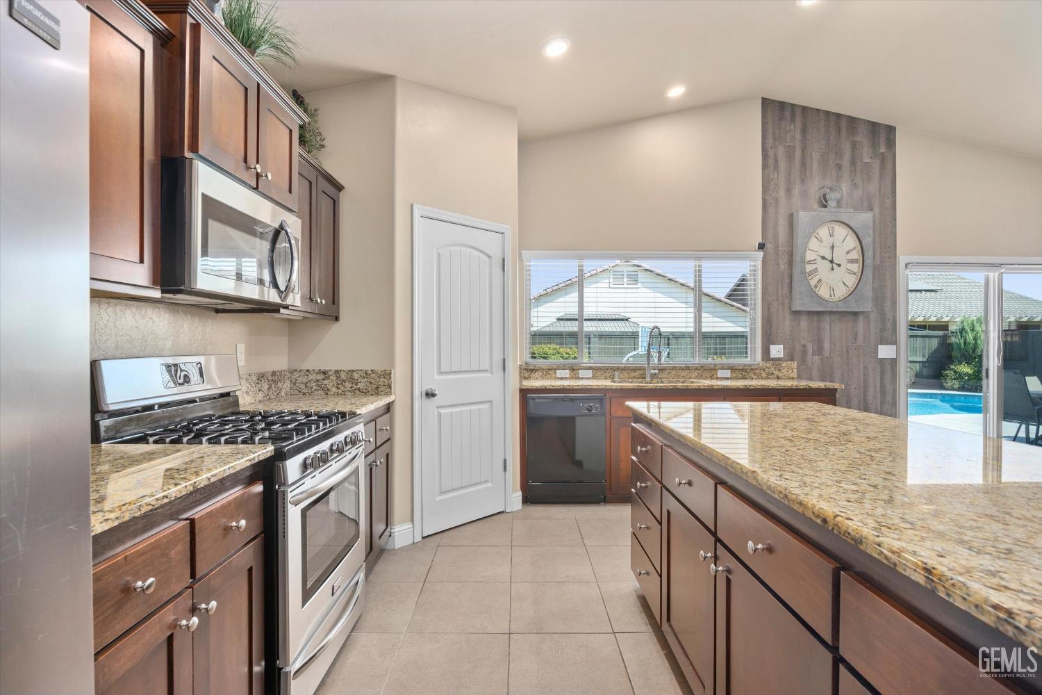 Undisclosed Address Shafter, CA 93263 - Photo 18 of 40 a kitchen with stainless steel appliances granite countertop a stove a sink and a microwave
