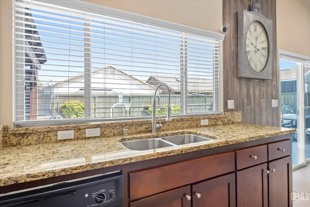 a bathroom with a granite countertop sink and a large window
