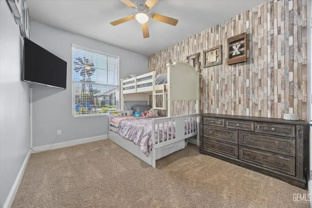 a bedroom with a bed and a flat tv screen on dresser