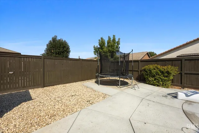 a view of backyard with a patio and potted plants