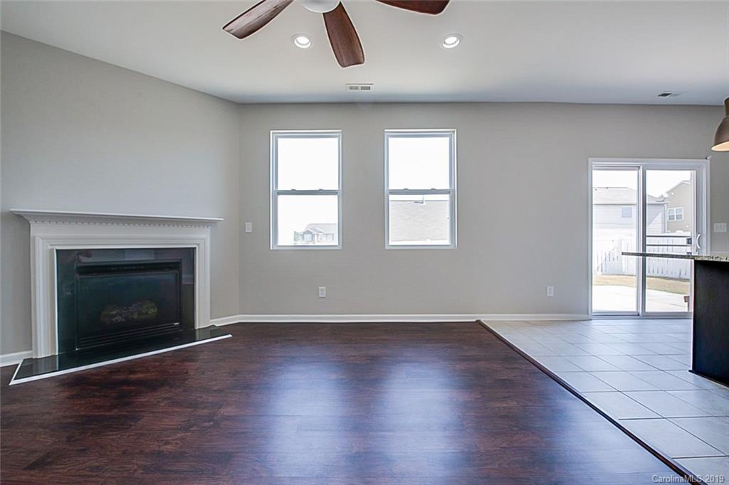 1022 Yellow Bee Road Indian Trail, NC 28079 - Photo 10 of 20 an empty room with wooden floor fireplace and windows