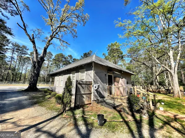 a view of a house with wooden fence next to a yard