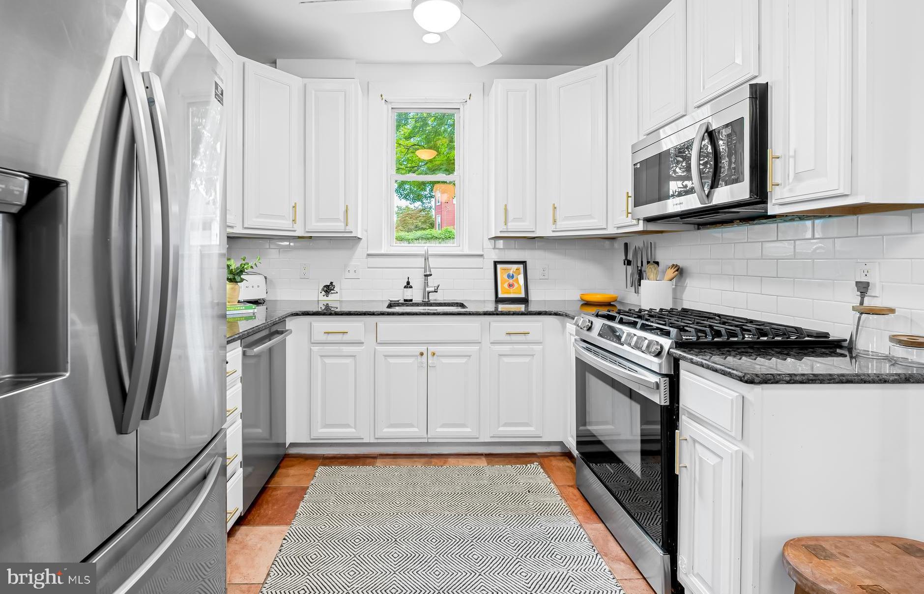 5009 Catalpha Road Baltimore, MD 21214 - Photo 11 of 38 a kitchen with stainless steel appliances granite countertop a refrigerator stove top oven and sink