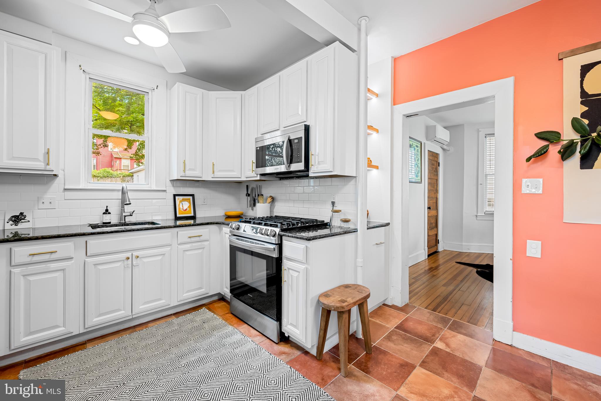 5009 Catalpha Road Baltimore, MD 21214 - Photo 14 of 38 a kitchen with stainless steel appliances granite countertop a stove a sink and a microwave