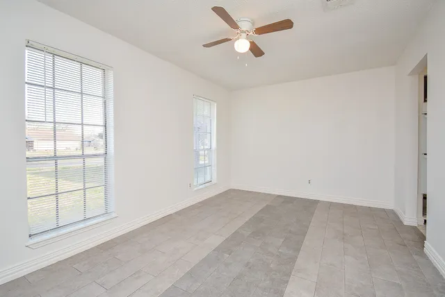 an empty room with a empty space and a ceiling fan