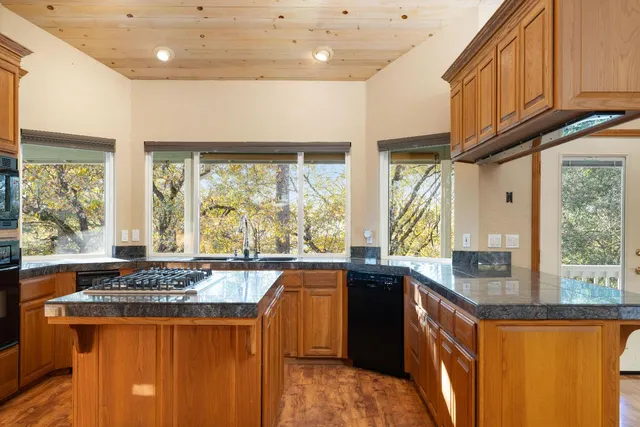 a kitchen with stainless steel appliances granite countertop a sink a stove and a refrigerator
