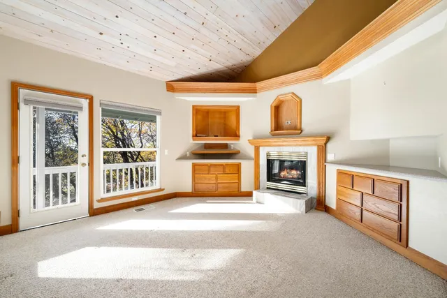 a view of an empty room with a fireplace and a window
