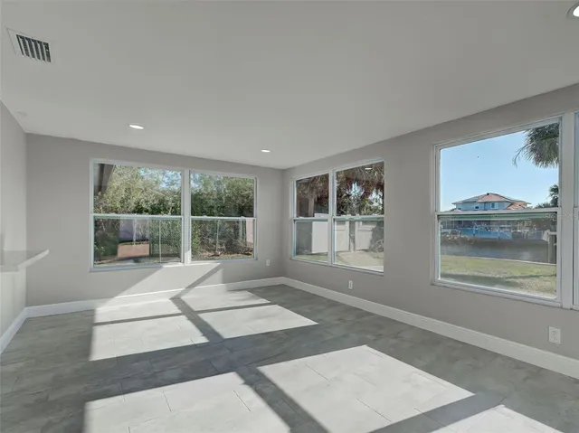 an empty room with a window and a fan