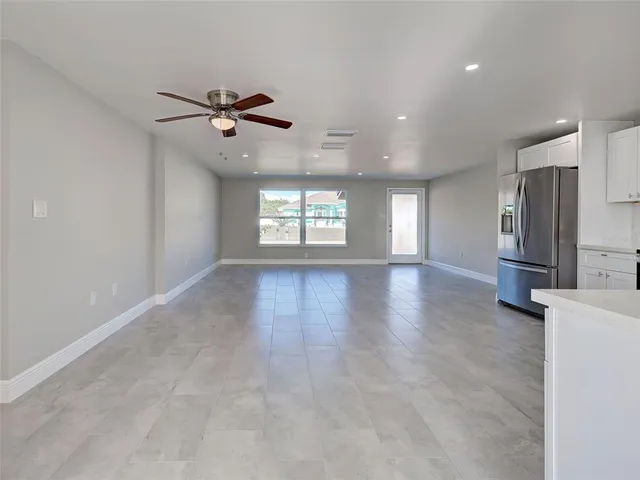 an empty room with window and ceiling fan