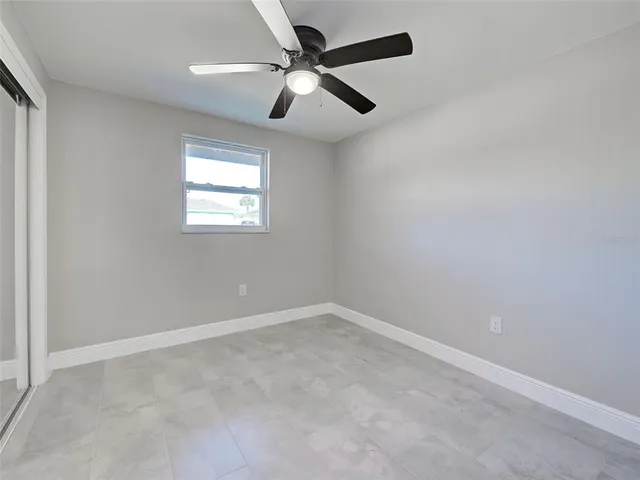 an empty room with windows and fan