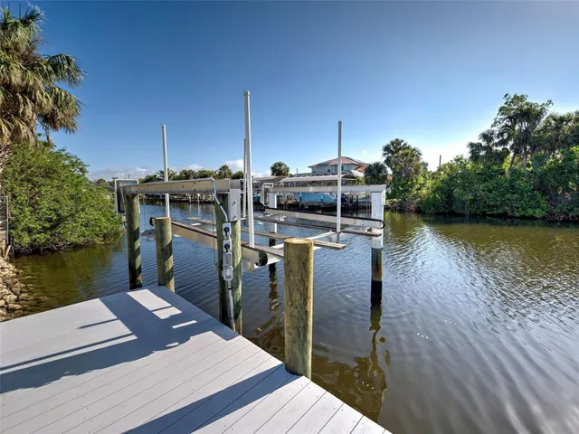 an empty room with windows ceiling fan and wooden floor