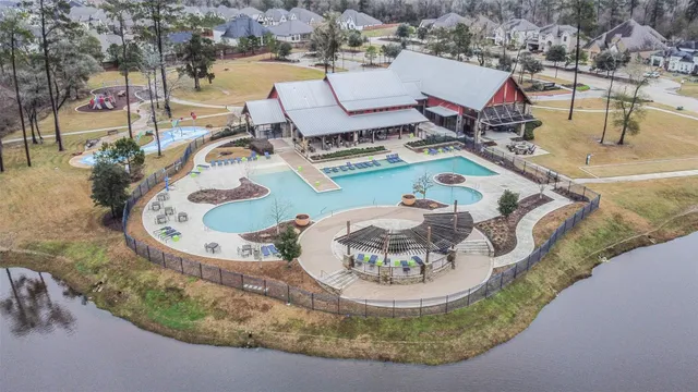 an aerial view of a house with swimming pool and lake view