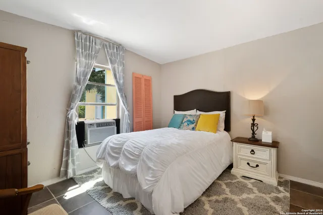 a bedroom with a bed a mirror and lamp