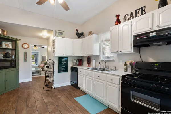 a kitchen with stainless steel appliances granite countertop a stove top oven a sink dishwasher and cabinets with wooden floor