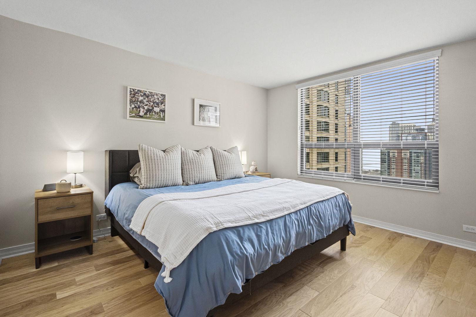 401 East Ontario Street, Unit 3102 Chicago, IL 60611 - Photo 16 of 29 a bedroom with a bed and wooden floor