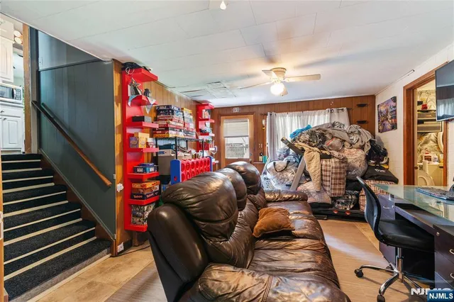 a living room with furniture a flat screen tv and a large window