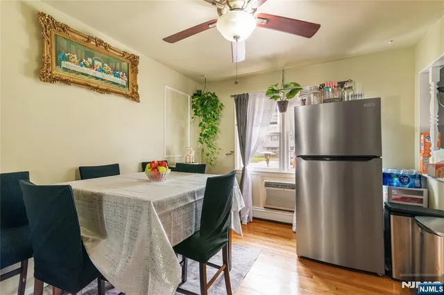 a kitchen with stainless steel appliances granite countertop a refrigerator a stove a sink dishwasher and a dining table with wooden floor