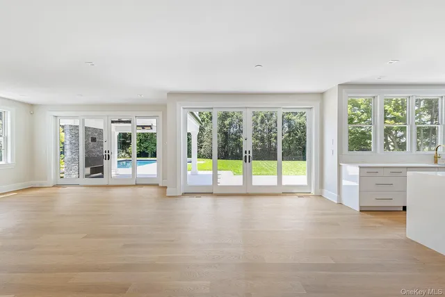 a large white kitchen with granite countertop a large counter top and stainless steel appliances