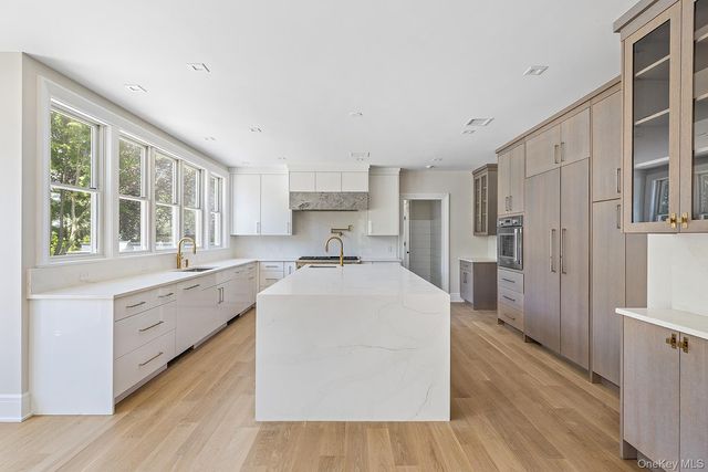 a large kitchen with cabinets a sink dishwasher and a stove