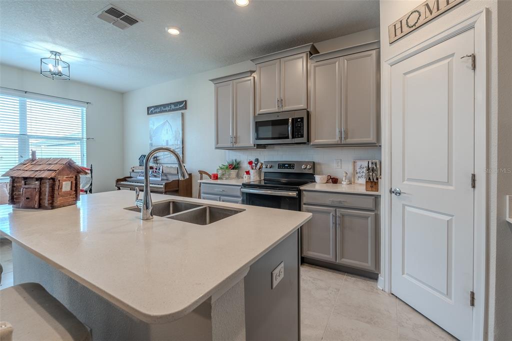 9224 Southwest 60th Ct Road Ocala, FL 34476 - Photo 11 of 55 a kitchen with kitchen island a sink stove top oven and microwave