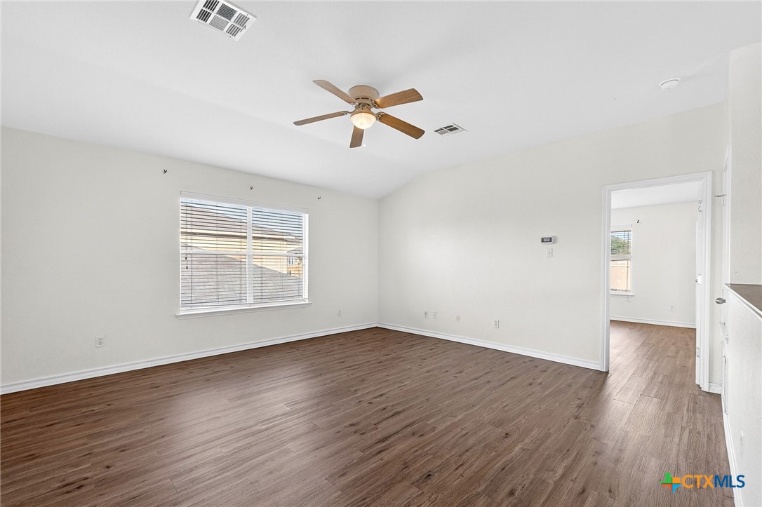 6204 Taree Loop Killeen, TX 76549 - Photo 9 of 24 an empty room with wooden floor a ceiling fan and windows