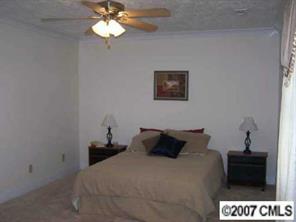 2318 Goldmine Road Monroe, NC 28110 - Photo 5 of 8 a bedroom with a bed and a chandelier