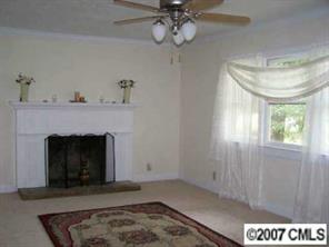 2318 Goldmine Road Monroe, NC 28110 - Photo 7 of 8 a living room with a fireplace and chandelier