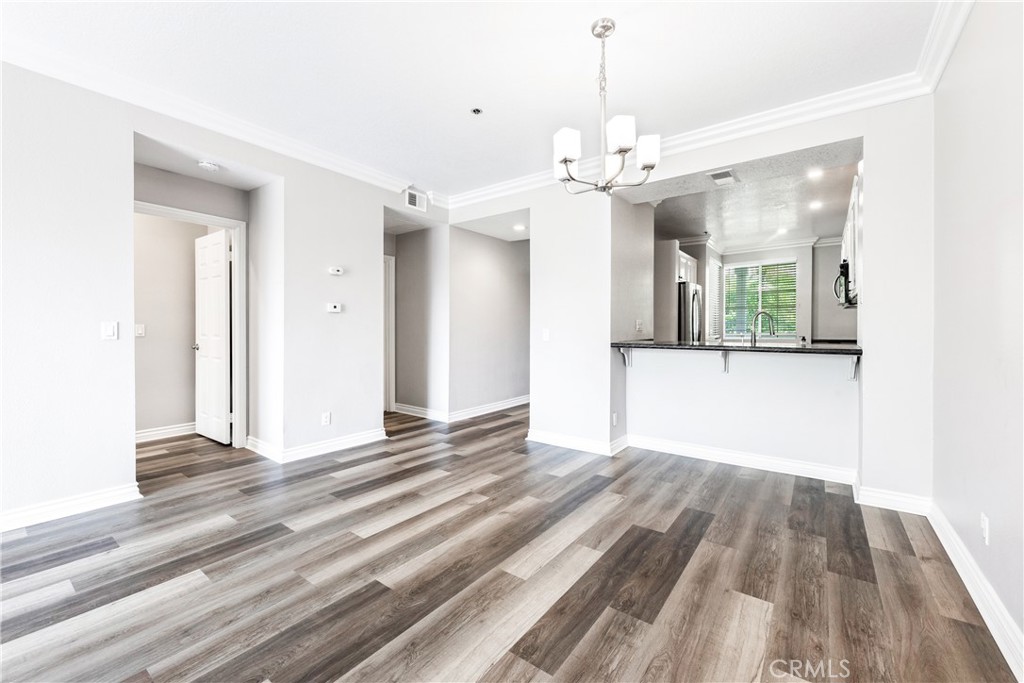 20301 Bluffside Circle, Unit 304 Huntington Beach, CA 92646 - Photo 19 of 36 a view of a room with wooden floor and a ceiling fan