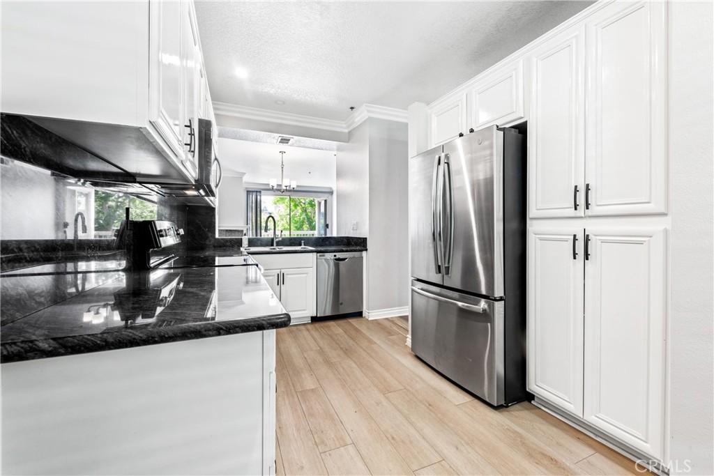 20301 Bluffside Circle, Unit 304 Huntington Beach, CA 92646 - Photo 21 of 36 a kitchen with stainless steel appliances a refrigerator and a sink
