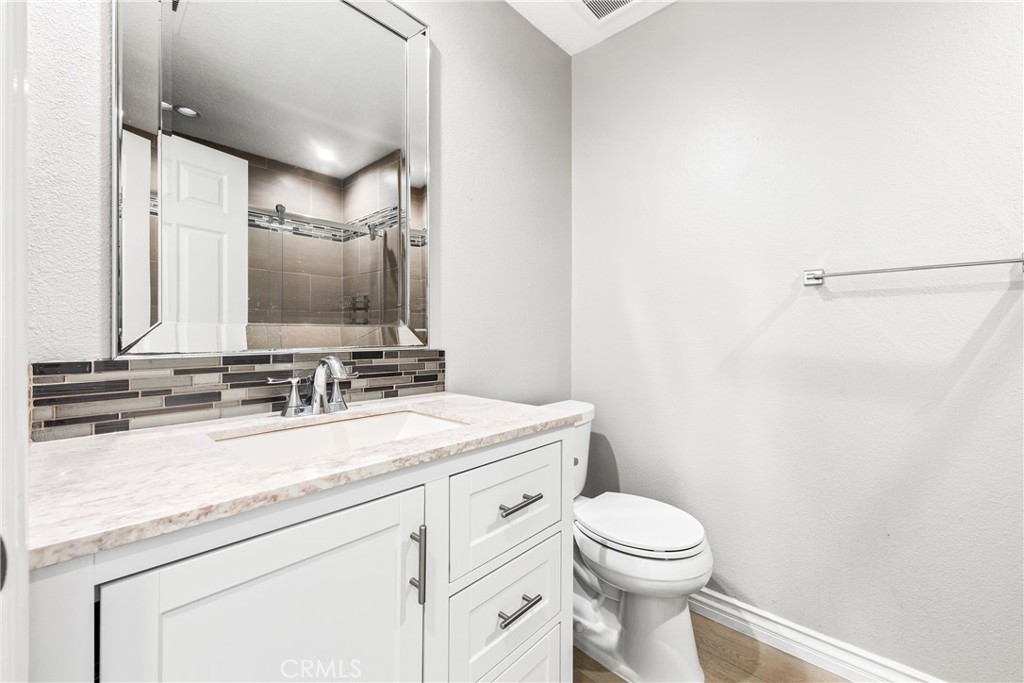 20301 Bluffside Circle, Unit 304 Huntington Beach, CA 92646 - Photo 25 of 36 a bathroom with a toilet sink vanity and mirror