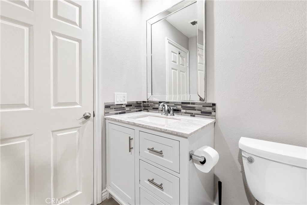 20301 Bluffside Circle, Unit 304 Huntington Beach, CA 92646 - Photo 26 of 36 a bathroom with a sink a toilet and a mirror