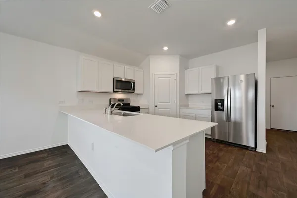 a kitchen with stainless steel appliances a refrigerator sink and microwave