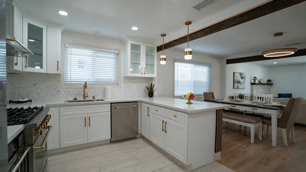 a kitchen with a stove a sink a window and dining table