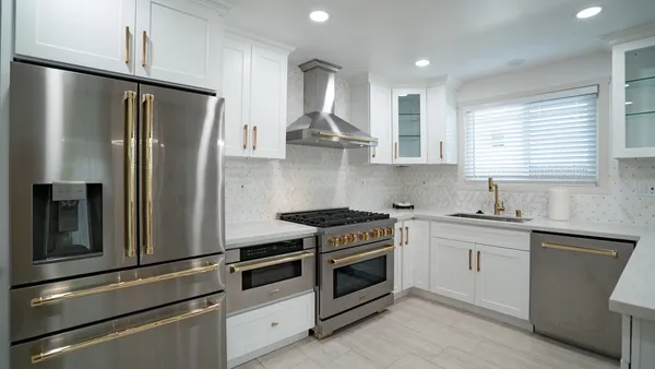 a kitchen with stainless steel appliances granite countertop a stove a refrigerator and a sink