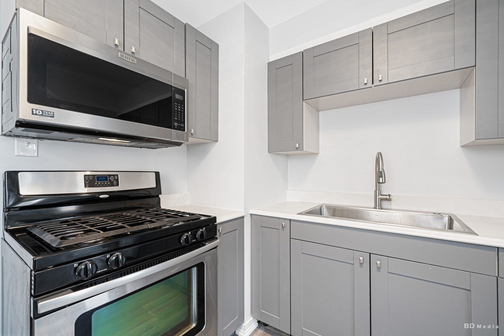 446 Warren Street Calumet City, IL 60409 - Photo 3 of 20 a kitchen with stainless steel appliances a sink a stove and microwave