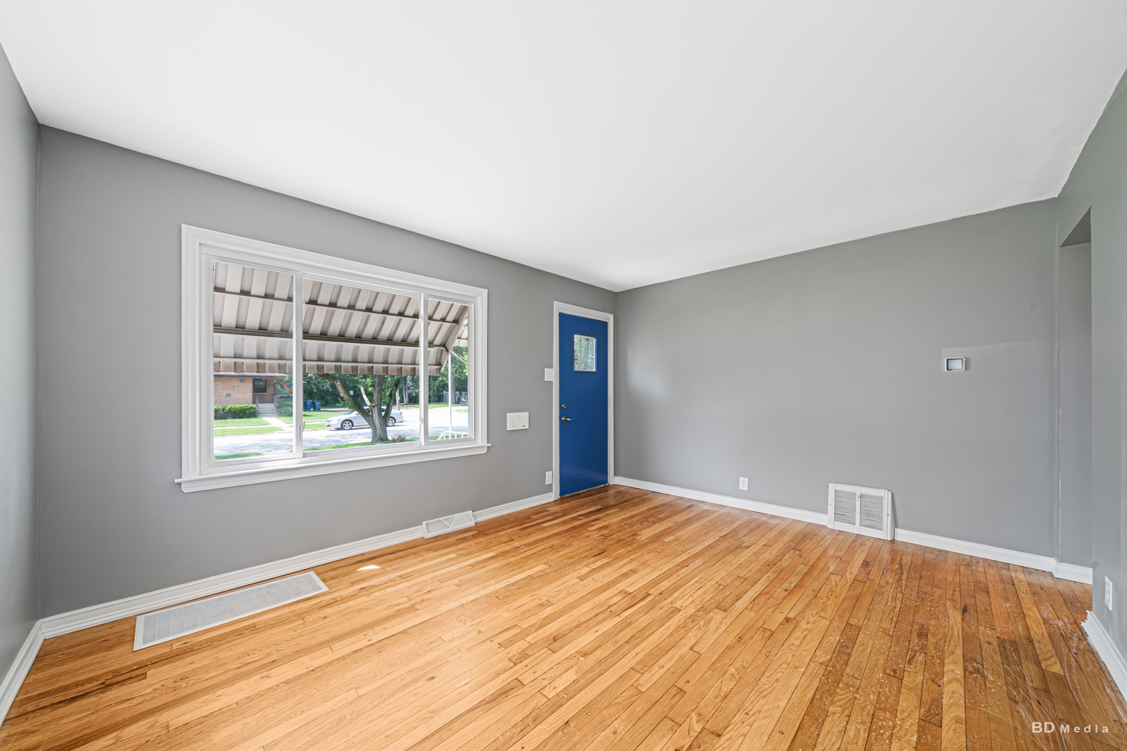 446 Warren Street Calumet City, IL 60409 - Photo 7 of 20 a view of an empty room with wooden floor and a window