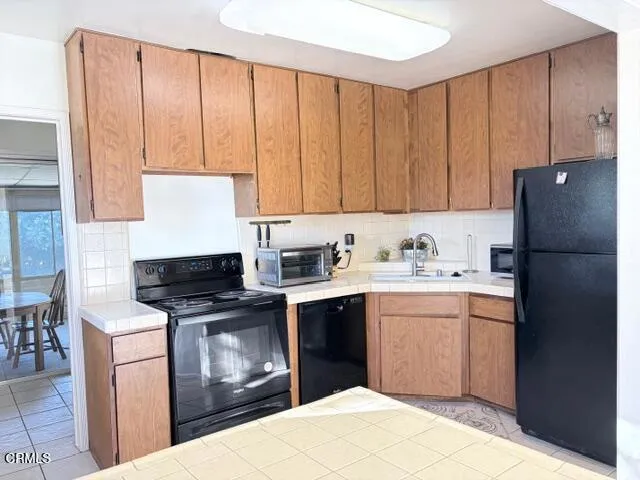 a kitchen with a sink a refrigerator and cabinets